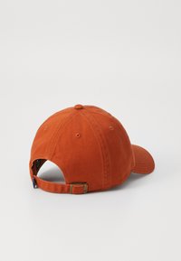 Oranges Baumwoll-Baseballcap mit gebogenem Schirm, Lüftungsöffnungen und einem verstellbaren Metall-Schnallenriemen hinten. Strukturiertes Stoffdetail.