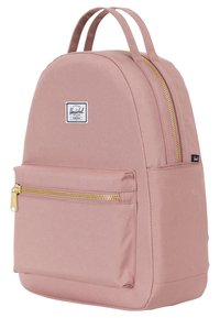 Różowy plecak z zaokrąglonym kształtem, złotymi zamkami błyskawicznymi, przednią kieszenią oraz metką markową z przodu. Dwa uchwyty do noszenia.