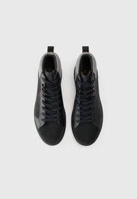 Black high-top sneakers with a smooth leather exterior, textured gray knit collar, and black laces. Includes red logo detail on the side.