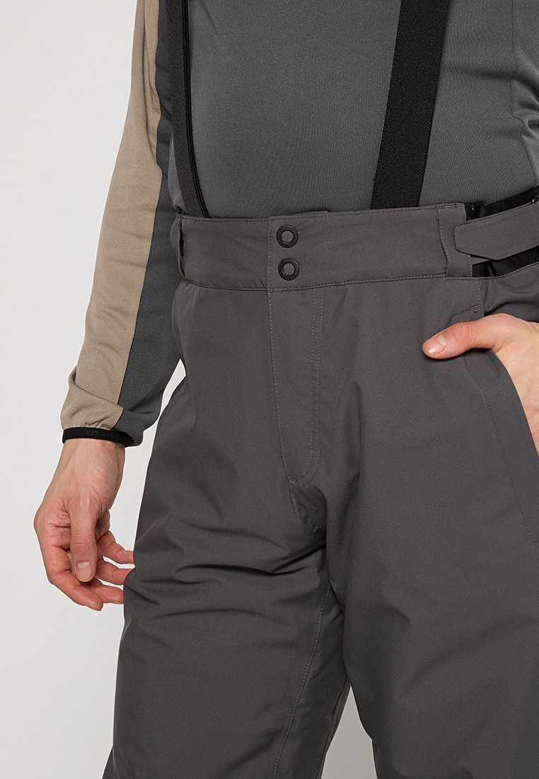 Szare wodoodporne spodnie z regulowanymi szelkami, o gładkiej fakturze, z zapięciem na guziki i detalami w formie bocznych kieszeni.