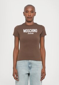 Brązowa dopasowana koszulka z krótkim rękawem, z białym logo "MOSCHINO JEANS" na piersi. Miękka tkanina o gładkiej fakturze.