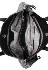 Sac noir avec un matériau extérieur texturé. L'intérieur présente des compartiments zippés et une doublure à motifs gris clair avec du texte.