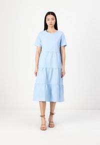 Vestido em azul claro, de algodão, com mangas curtas em camadas, gola redonda, três camadas de tecido e uma bainha inferior fluida.