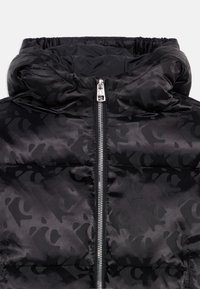 Chaqueta acolchada negra con sutil patrón de leopardo, cuello alto acolchado y cremallera frontal plateada con tirador.