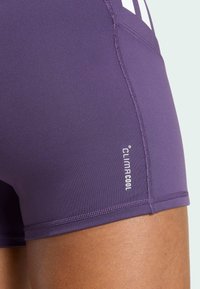 Paarse sportshorts gemaakt van glad, ademend materiaal. Voorzien van ClimaCool-logo en contrasterende stiksels langs de naden.
