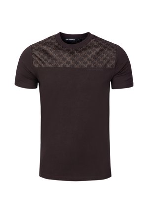 T-shirt à manches courtes col rond de couleur brun foncé avec un panneau à motifs traversant la partie supérieure de la poitrine et les épaules.