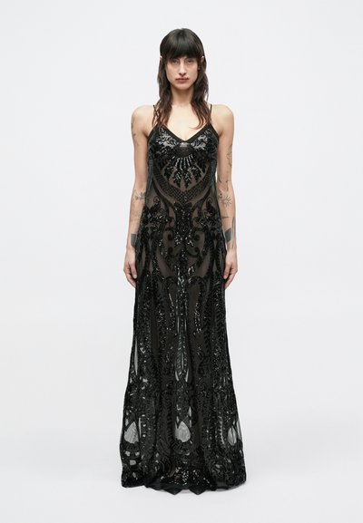 Robe noire longue jusqu'au sol en tissu transparent avec des motifs de perles complexes. Caractérisée par des bretelles fines et des embellissements détaillés en sequins.