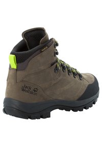 Stivale da trekking marrone con superficie texturizzata, punta nera in gomma, lacci grigi e accenti gialli vicino alla caviglia. Presenta il logo Jack Wolfskin.
