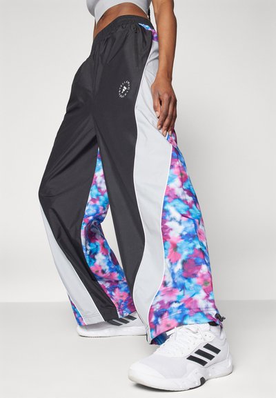 Mustat ja harmaat urheiluhousut, joissa on värikäs sitruunakuvio sinisen ja vaaleanpunaisen sävyssä. Sisältää sivupaneelit ja vetoketjutaskun. Täydelliset rentoon pukeutumiseen.