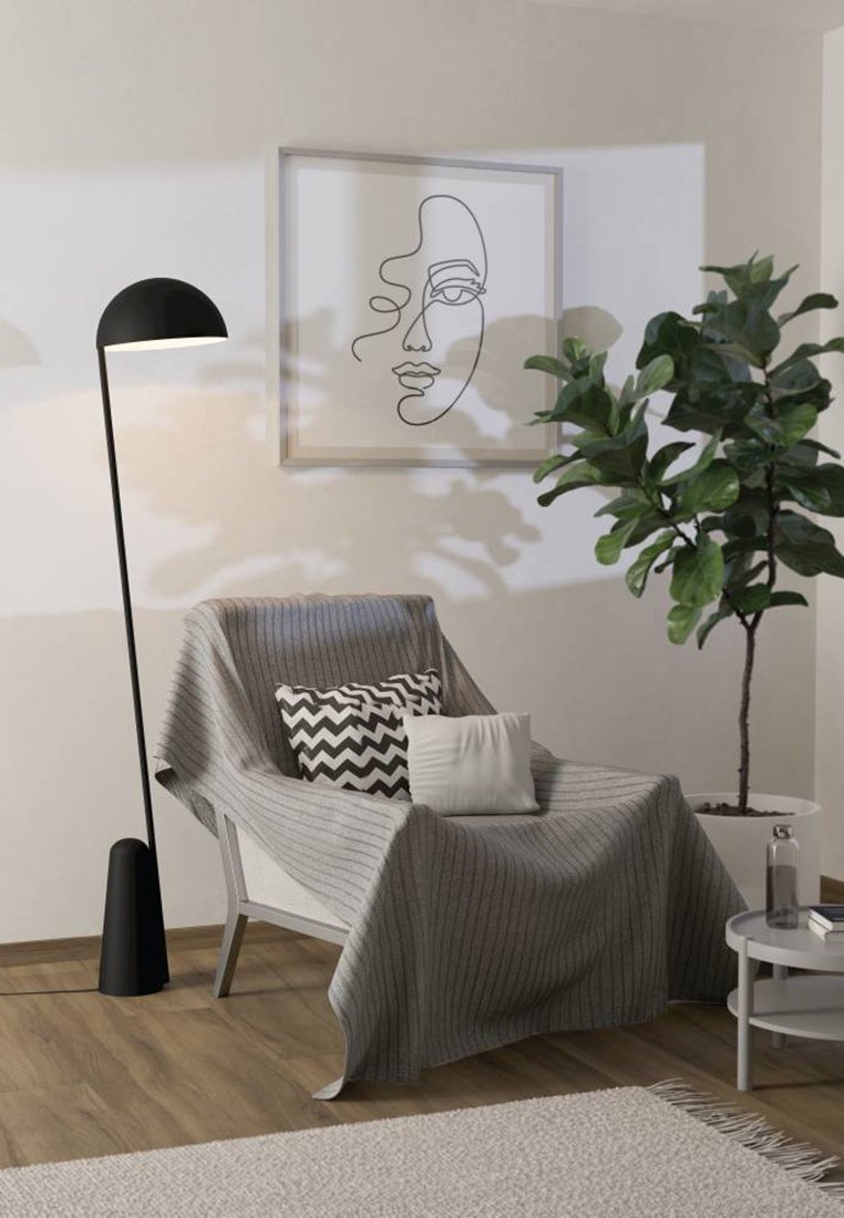 Grau gestreifete Decke liegt über einem weißen Liegestuhl. Schwarze Stehlampe, gemusterte Kissen, Zimmerpflanze und runder Beistelltisch mit einer Tasse.