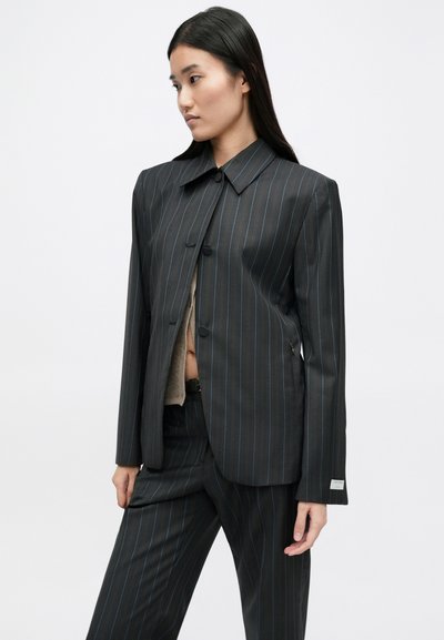 Zwart kostuumjack met krijtstrepen, een kraag met een boord, een enkele knoopsluiting en lange mouwen, voorzien van blauwe accenten en een gladde textuur.