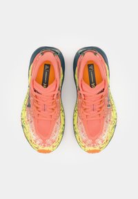 Trail running shoes with a breathable, patterned pink and yellow upper, featuring dark blue accents and a rugged sole for traction.