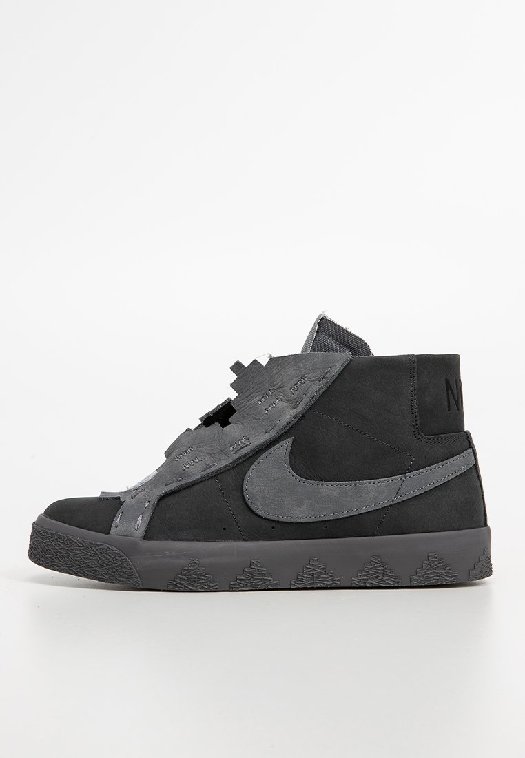 Sneaker Nike alto nero e grigio scuro con parte superiore strappata e parzialmente staccata e suola texturizzata, mostrato in profilo laterale su sfondo bianco.