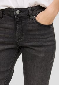 Zwarte denim jeans met een standaard knoop- en ritsluiting, met subtiele vervaging, een vijf-pocket ontwerp en een strakke pasvorm.