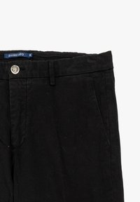 Pantaloni di cotone neri con una texture liscia, dotati di tasche frontali, chiusura con bottone e un'etichetta blu del brand in vita.