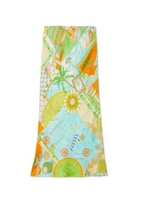 Jupe longue avec imprimé coloré sur le thème des vacances comprenant soleil, palmiers, sections de carte, fleurs et éléments de plage dans des tons verts, orange et bleus.
