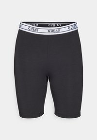 Shorts noirs en coton extensible avec un design ajusté, présentant une ceinture blanche avec le logo 'GUESS'. Texture lisse, longueur mi-cuisse.