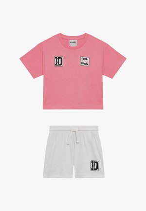 T-shirt corta a maniche corte rosa con toppe nere e bianche e pantaloncini bianchi con coulisse e toppa abbinata sulla gamba sinistra.