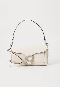 Sac à main en cuir crème avec une forme structurée, équipé d'une fermeture décorative en forme de 'C' accentuée de doré et d'une bandoulière amovible.