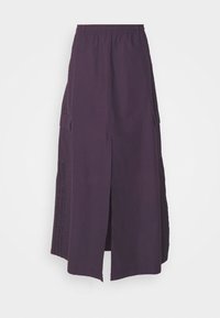 Lila maxikjol med vertikalt ribbad textur, elastisk midja, sidofickor och en framre slits för lätt rörelse.