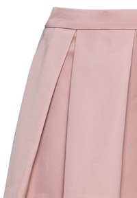 Rosa plisserad kjol i mjukt material, med en åtsittande midja och subtil lyster. Inga ytterligare mönster eller dekorativa inslag.