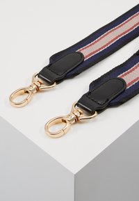 Sangle en tissu bleu marine et noir avec des clips métalliques dorés, présentant des rayures horizontales en rose et argent. Accents en cuir texturé aux extrémités.