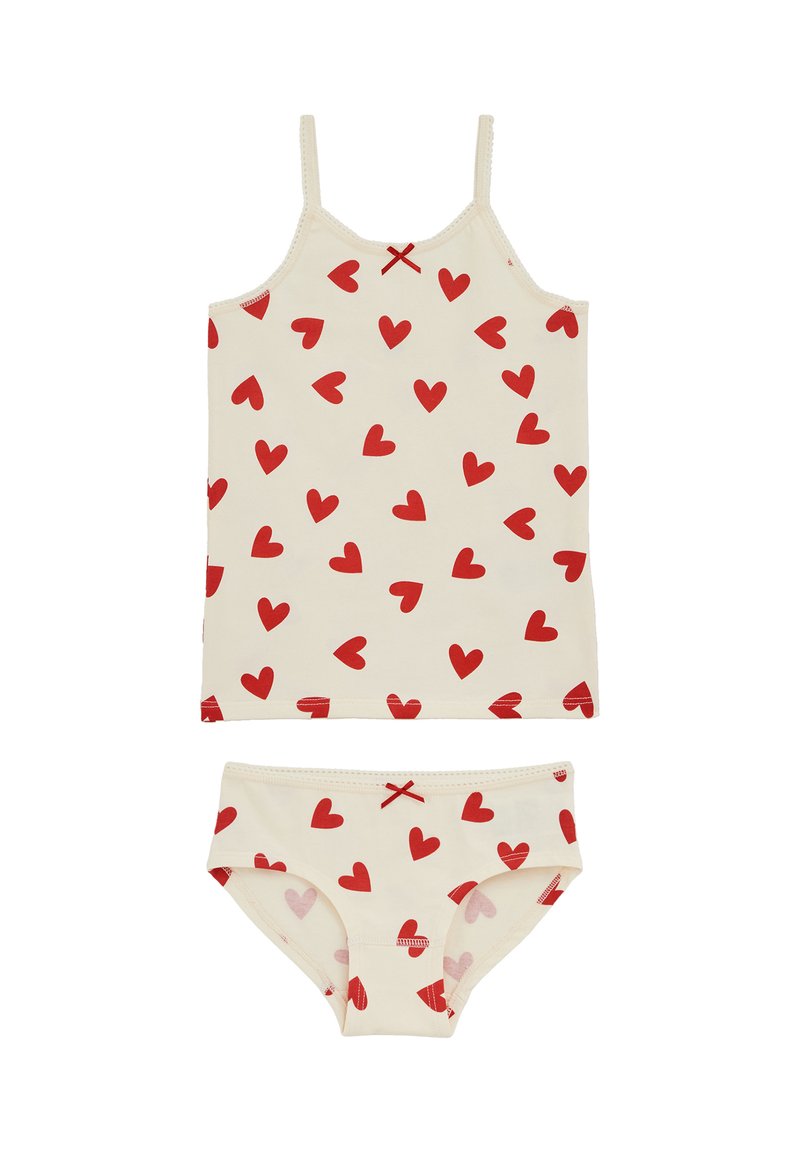 Súprava dievčenskej tielkovej blúzky a nohavičiek v krémovej farbe s roztrúsenými červenými srdiečkami a malými červenými mašličkami na oboch kúskach.