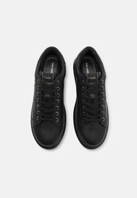 Zwarte leren sneakers met een ronde neus, platte veters en gestikte details. Voorzien van een logotag op de tong en een gepolijste textuur.