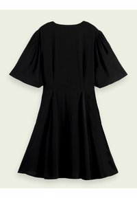 Robe noire longueur genou avec de larges manches bouffantes au niveau du coude et une taille cintrée, présentée sur un fond clair.