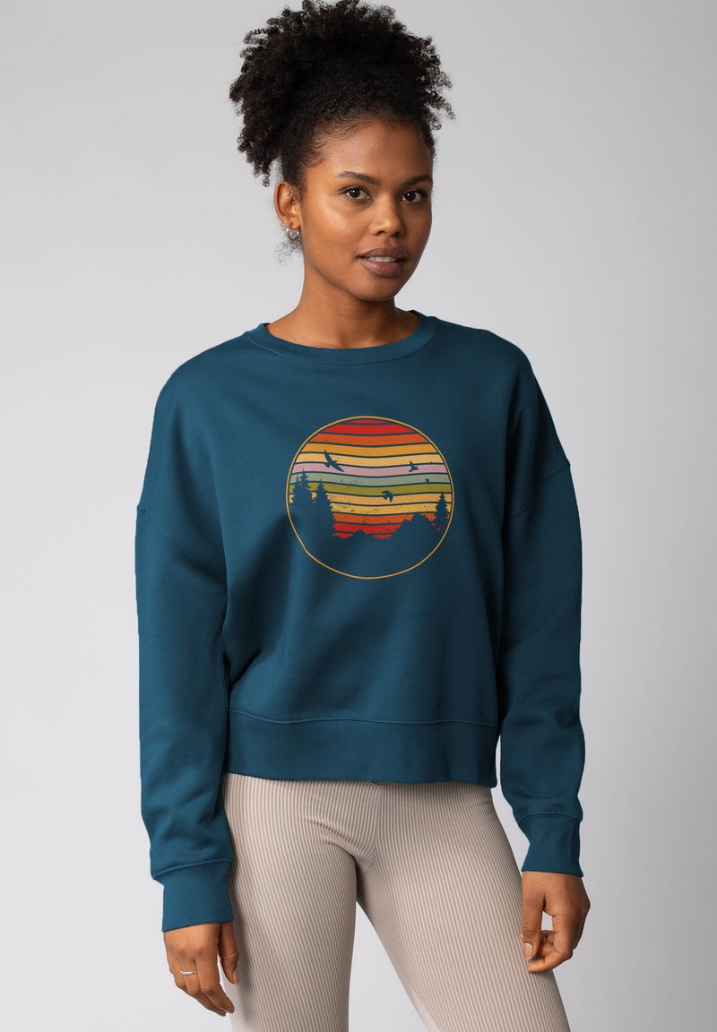 Teal sweatshirt met een ronde graphic met kleurrijke strepen, bergen en vogels. Losse pasvorm, geribde manchetten en zoom. Gelaagd materiaal.