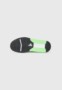 Crna i zelena atletska obuća sa potplatom koji ima teksturirani uzorak za prianjanje, s belim akcentima i izvanrednim adidas logotipom.