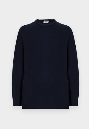 Sweater de manga longa azul-marinho com gola redonda e uma pequena etiqueta branca dentro do colarinho com a inscrição "DRYKORN."