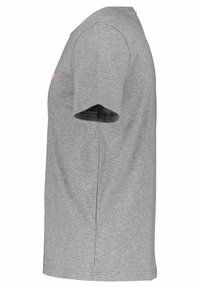 Boční pohled na obyčejné šedé tričko s krátkým rukávem s jemnou texturou na bílém pozadí.