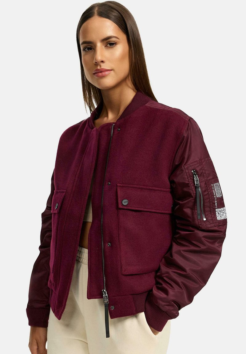 Maroon bomber jacket with a wool body and nylon sleeves, featuring button and zip pockets, ribbed cuffs, and a zip front.