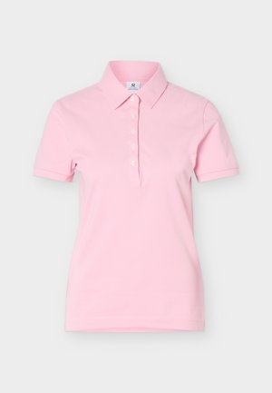 Απαλό ροζ κοντομάνικο πόλο μπλουζάκι με γιακά και πέντε λευκά κουμπιά μπροστά σε απλό ανοιχτό φόντο.