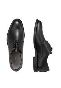 Scarpe eleganti in pelle nera con una texture liscia. Presentano un design con lacci, punta arrotondata e un tacco basso impilato. Linee pulite e minimalismo nei dettagli.