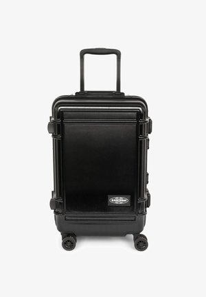 Twarda czarna walizka z metalicznym wykończeniem, wysuwanym uchwytem i czterema kółkami. Na przedniej części widoczne jest wyraźne logo marki.