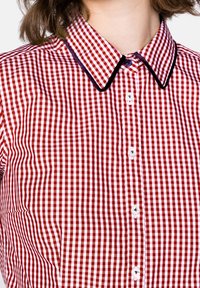 Punavalkoruudullinen paita, jossa on klassinen kaulus, napillinen etuosa ja kauluksen reunoilla kontrastinvärinen musta koristepitsi.