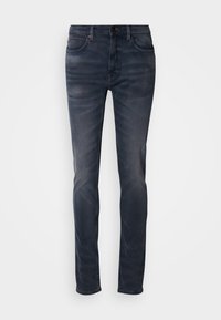 Mørk vaskede denimjeans med smal passform, utstyrt med knappelukking, fem lommer og subtil falming. Rett ben-design med jevn tekstur.