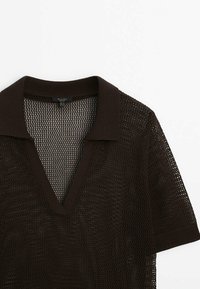 Chemise en maille à manches courtes, brun foncé, avec un motif en maille ajourée et un col et des poignets côtelés, présentant un décolleté en V profond.