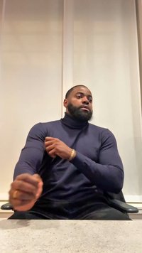 Granatowy golf o dopasowanym kroju, gładkiej fakturze i długich rękawach, zestawiony z ciemnymi spodniami. Swobodna, siedząca postawa.