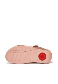 FitFlop sandaalzool, rubbermateriaal, lichtroze basis, textuursurface, prominente logo en cirkelvormige rode detail. Bovenkant heeft geweven, tan banden.