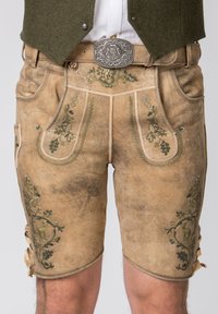 Shorts traditionnels en cuir tan, ornés de broderies florales vertes, avec poches latérales et lacets décoratifs sur les côtés. Détail de boucle en argent.