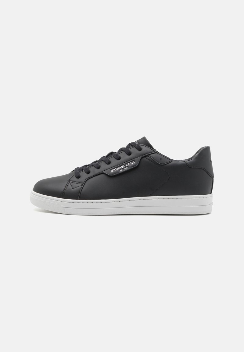 Black leather sneaker with a smooth finish, white rubber sole, round toe, six eyelet lacing system, and branded label on the side.