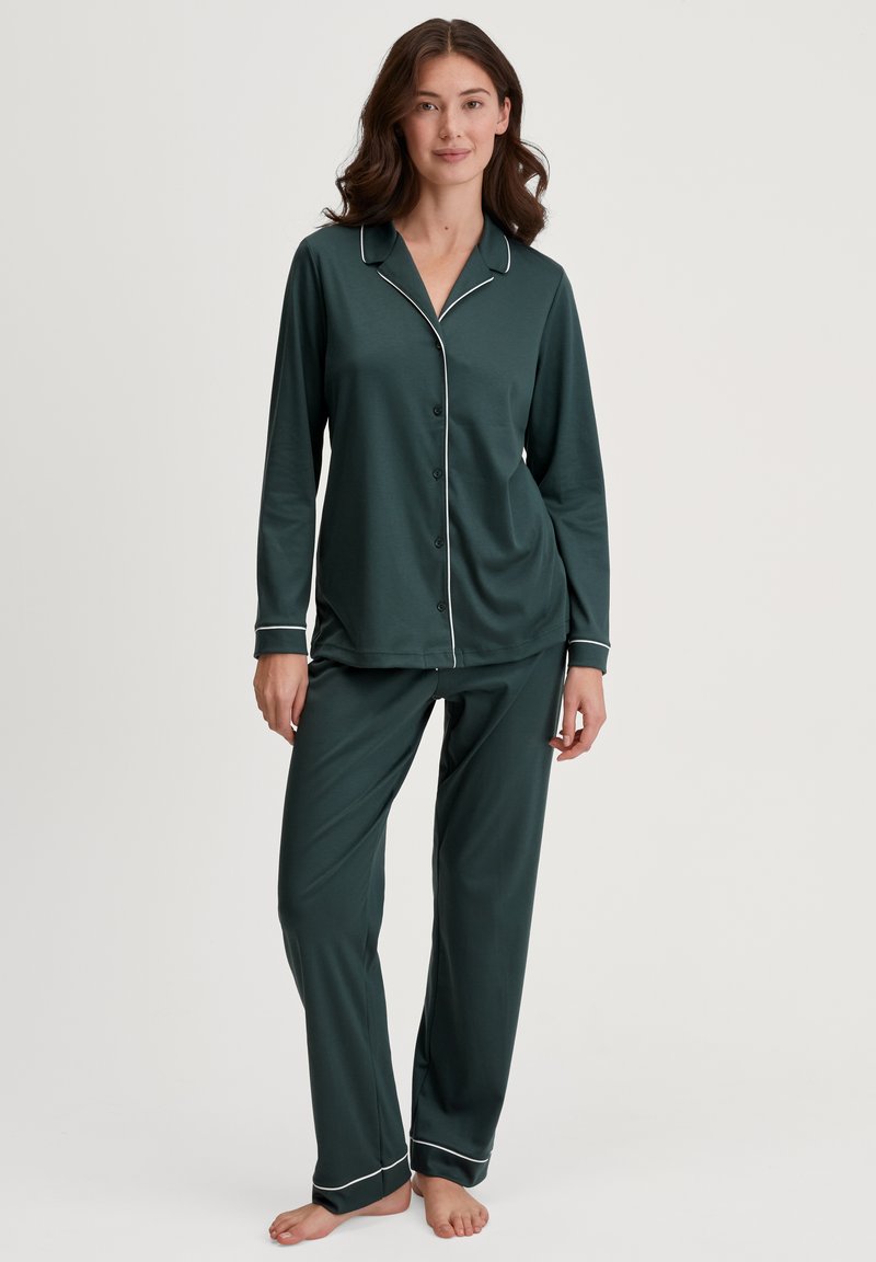 Waldgrünes Pyjama-Set aus weichem Stoff; verfügt über lange Ärmel, eine Knopfleiste vorne und weiße Paspelierungen an Kragen und Säumen.