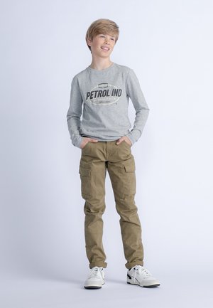 Graues Langarmshirt mit "PETROL IND" Grafik, kombiniert mit beigen Cargo-Hosen und weißen Sneakern, die mehrere Taschen und eine lockere Passform aufweisen.