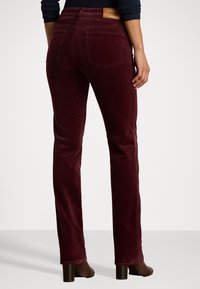 Burgunderfargede corduroy-bukser med rett ben-design, med baklommer og et skinnlogo-patch i midjen.