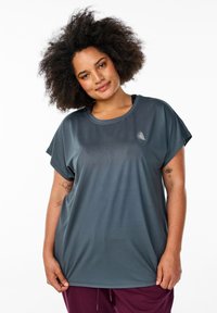 T-shirt oversize grigio scuro con maniche corte, scollatura rotonda e dettagli del logo sottili. Tessuto morbido e liscio adatto per l'abbigliamento attivo.
