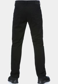 Czarne dżinsy o slim fit, z dwoma tylnymi kieszeniami i prostym krojem nogawek. Tkanina ma gładką teksturę i minimalne detale szwów.