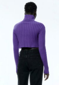 Paars geribbeld turtleneck trui met lange mouwen, cropped ontwerp, textuur gebreid materiaal. Gecombineerd met hoge taille zwarte spijkerbroek.